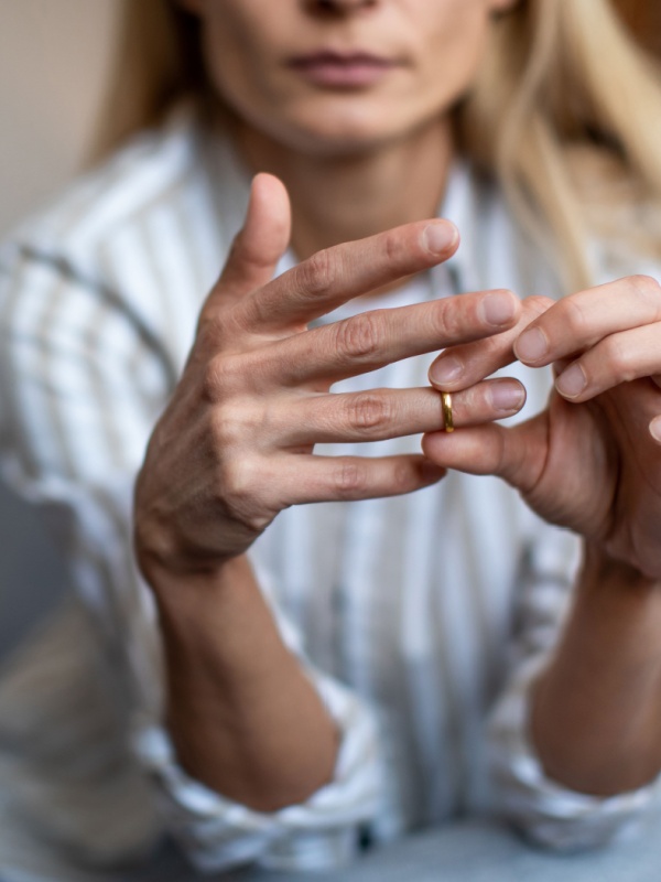 Woman removing her wedding ring as she begins the divorce process