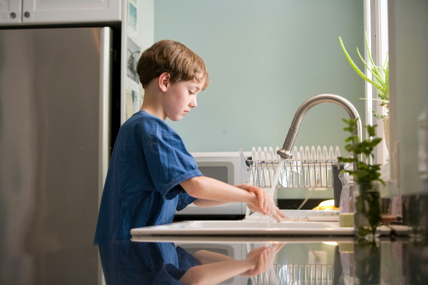 Boy Washing Hands in Kitchen