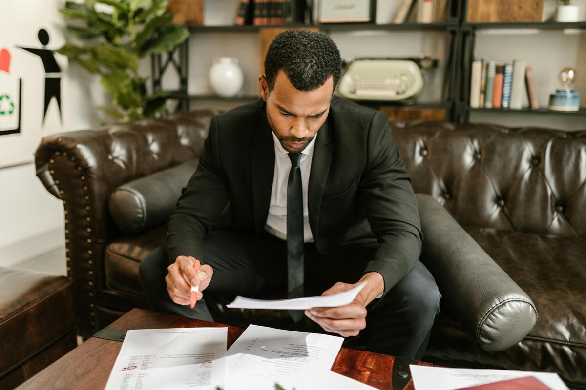 man signing sponsor license document