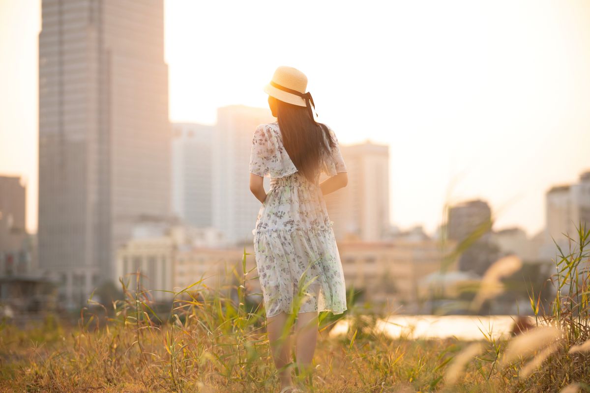 woman in a summer dress with city skyline