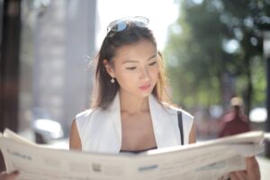woman reading newspaper with libel information