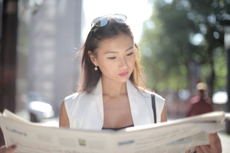 woman reading newspaper with libel information