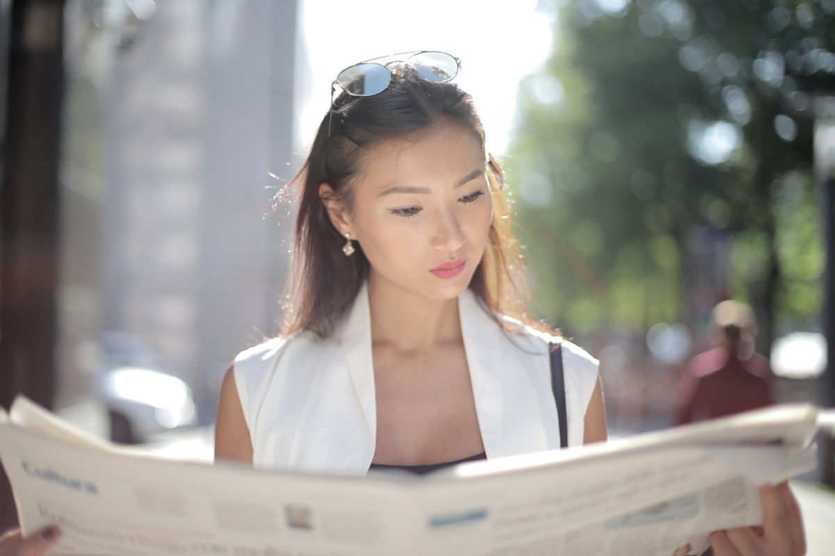 woman reading newspaper with libel information