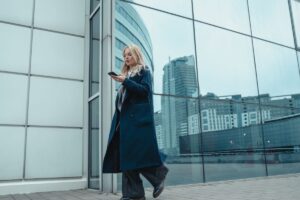 woman walking by glass wall with urban reflections