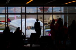 Silhouettes of travelers waiting at an airport terminal