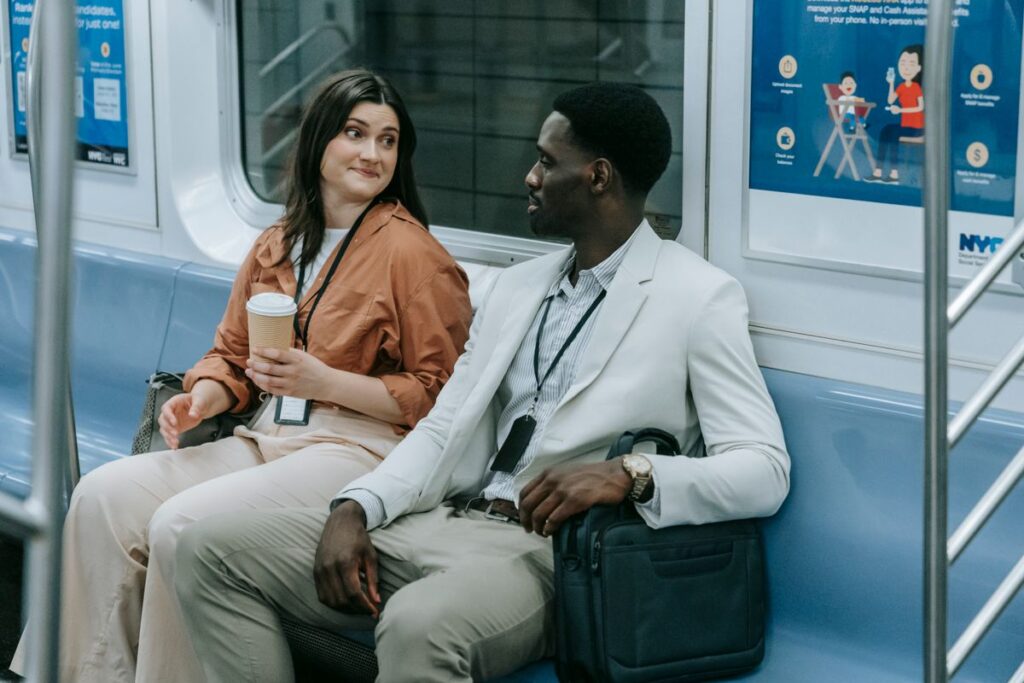 Two professionals chatting on a city subway train