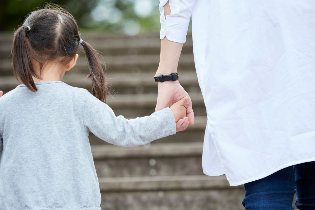 girl and dad holding hands