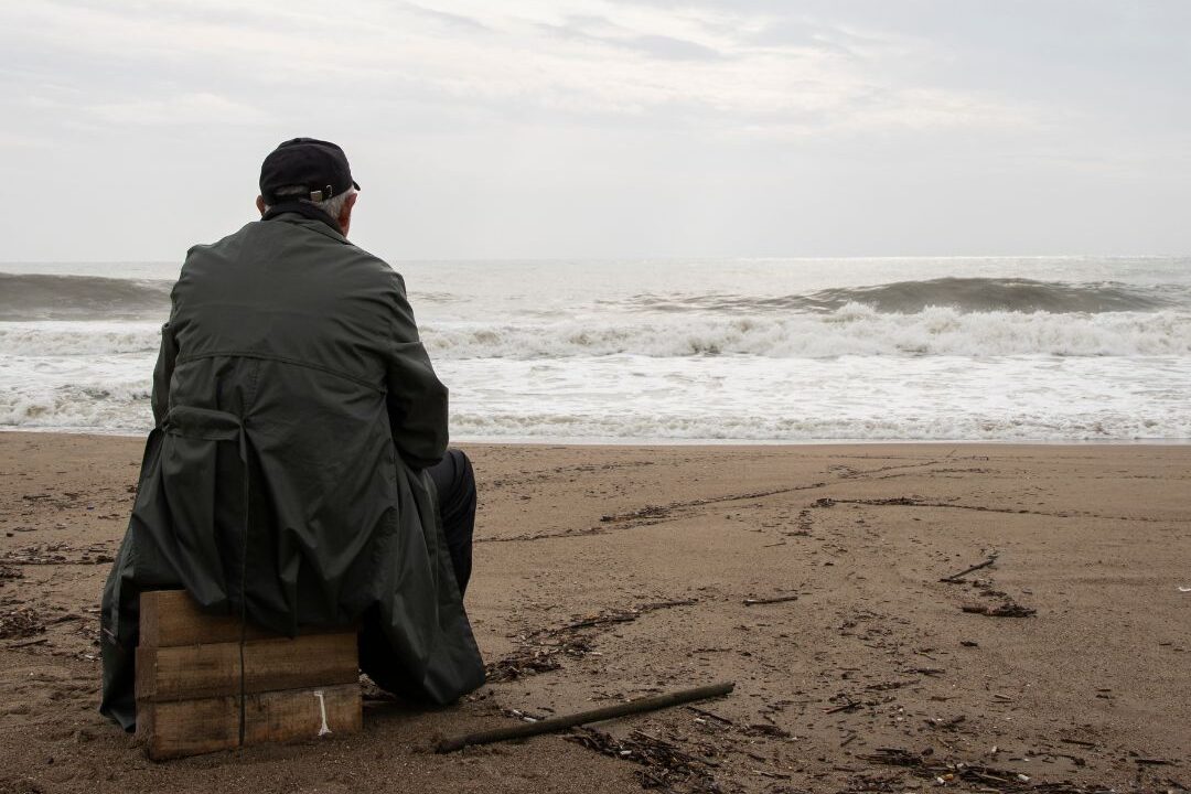man on beach with clouds
